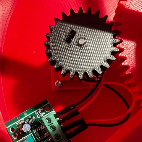 Close-up of the motor pinion and wired PWM controller inside the red printed base.